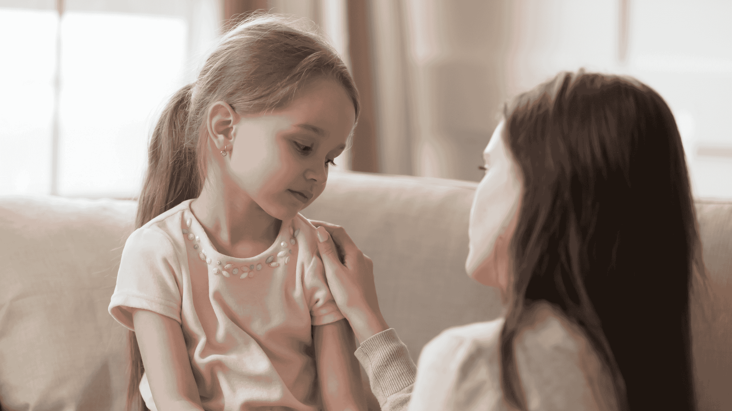 Niña conversando con su madre mientras señalan tarjetas con emociones, en un ambiente tranquilo y lleno de recursos visuales.